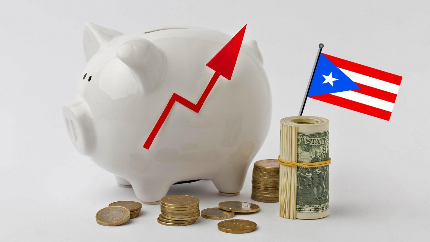 A white piggy bank beside currency and a Puerto Rican flag in a section that explains how prospective residents of Puerto Rico can lower their taxes with help from PRelocate.