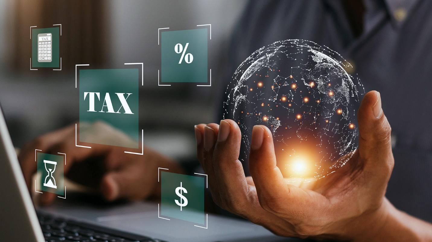 A person sitting at a laptop computer holds a digital globe of the earth beside finance-related icons in a section about the tax benefits available in some parts of the world.