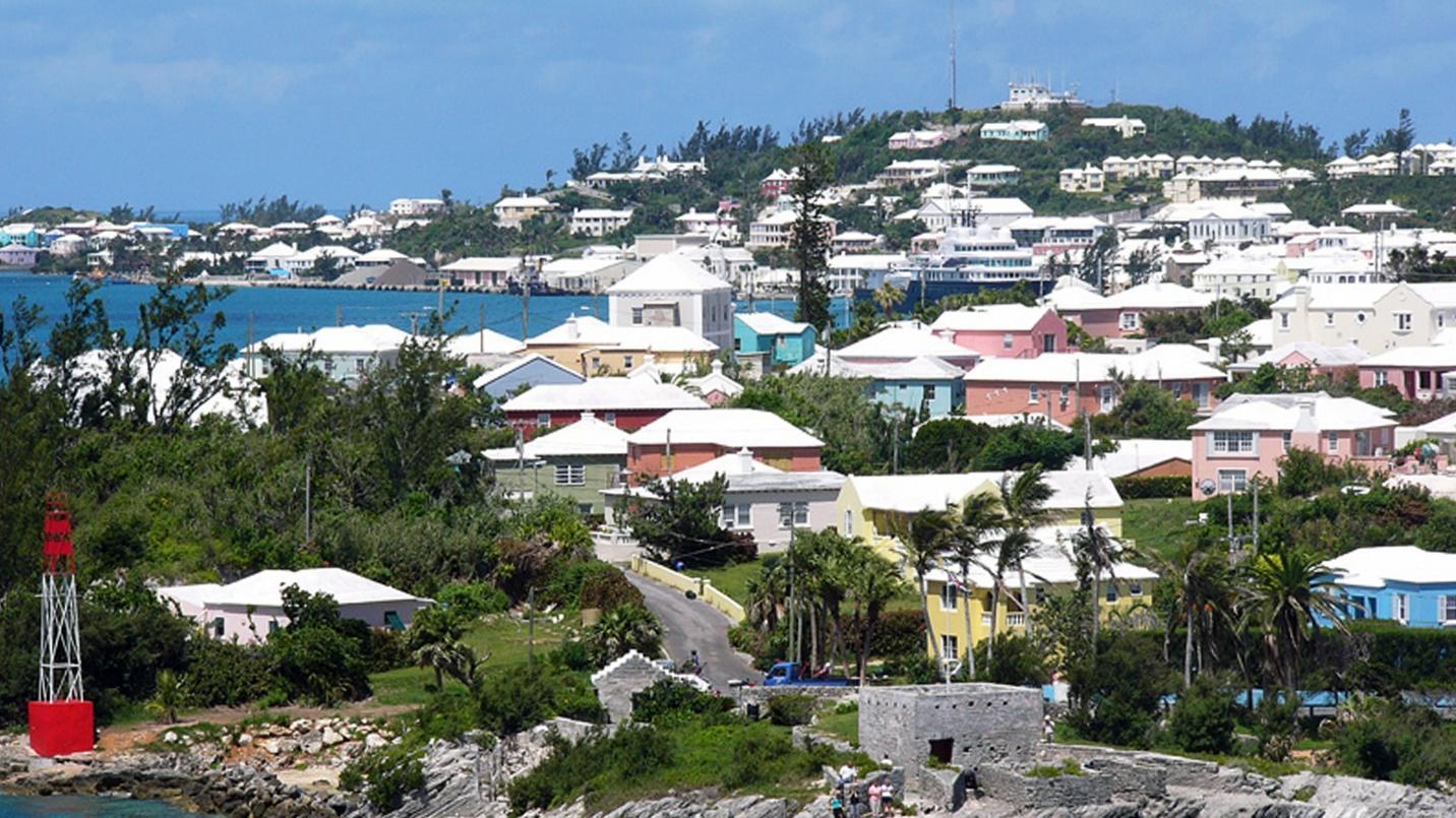 White-roofed homes and buildings by the sea in a section about the tax benefits available in Bermuda.