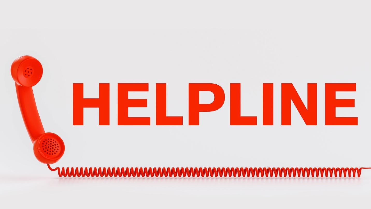 A red phone receiver and cord next to the word “HELPLINE” in a section about how to get assistance in the wake of a hurricane in Puerto Rico.