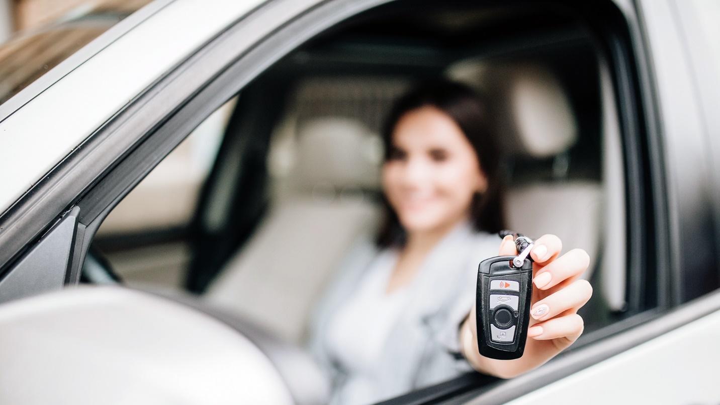 woman showing keys of a purchased used car in PR