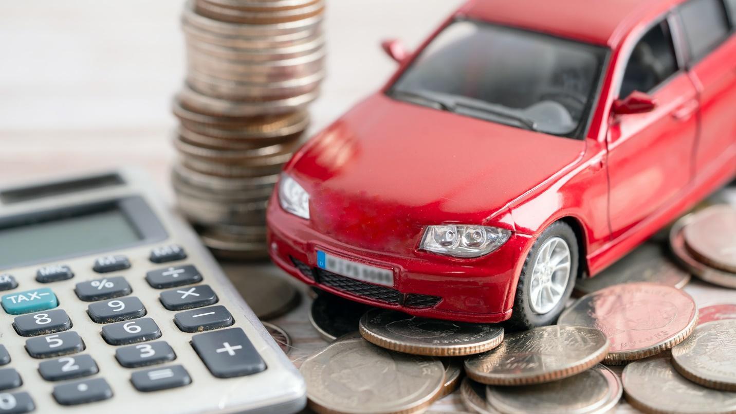 calculator and coins with a car miniature