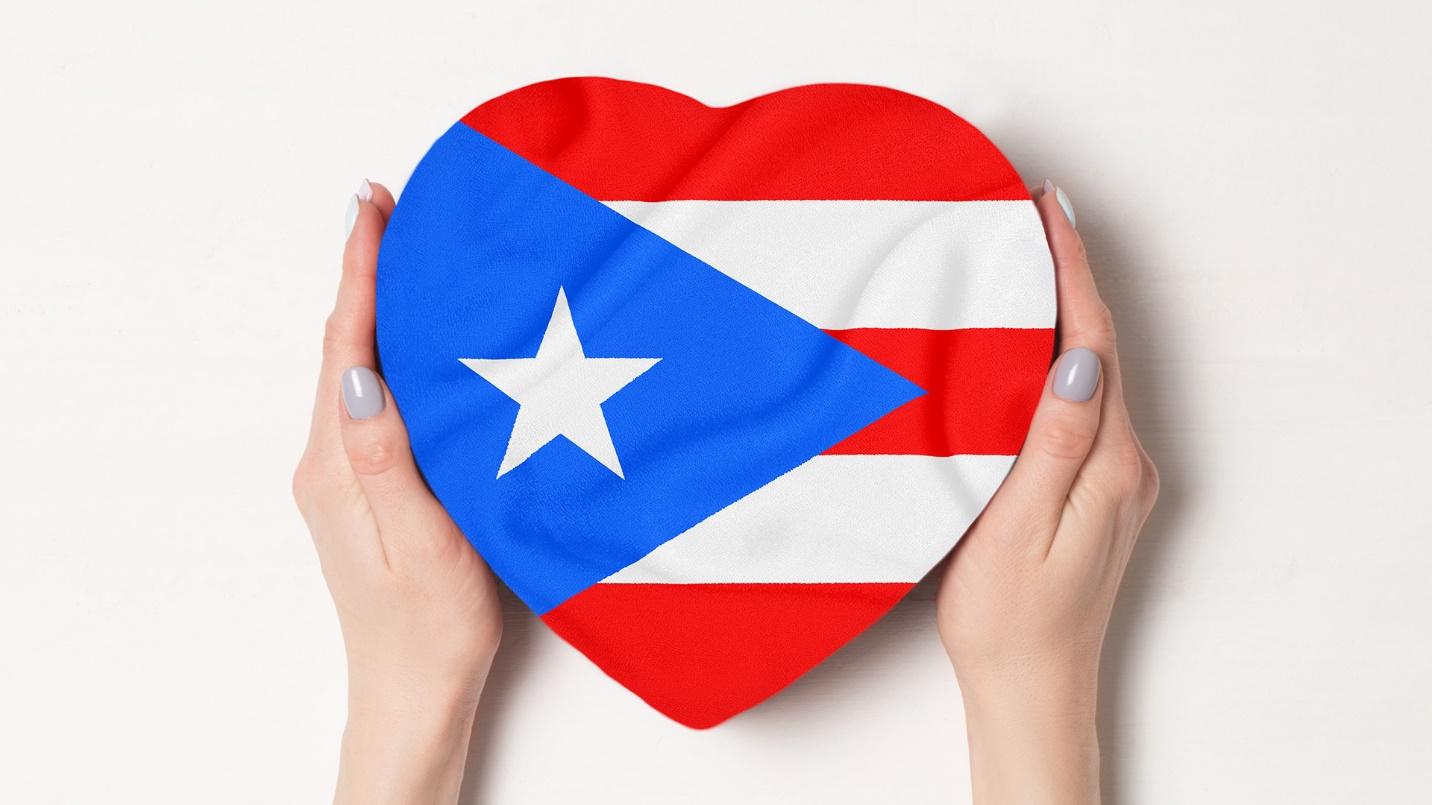 Hands clasp a heart-shaped box decorated with the Puerto Rican flag in a section that describes how to pass the closer connection test.
