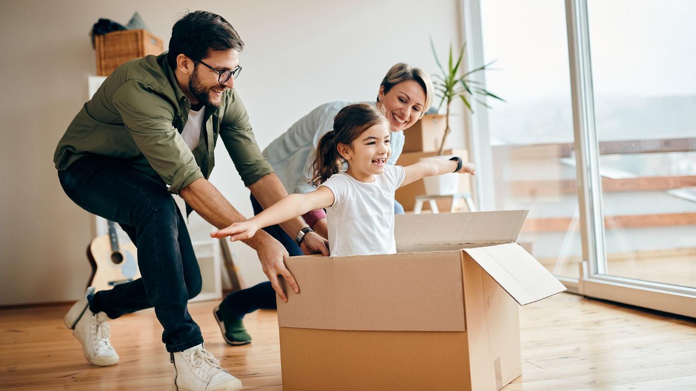 Smiling parents push their daughter around the floor in a cardboard box in a section describing the favorable tax status in Puerto Rico for those who move there from the mainland.

