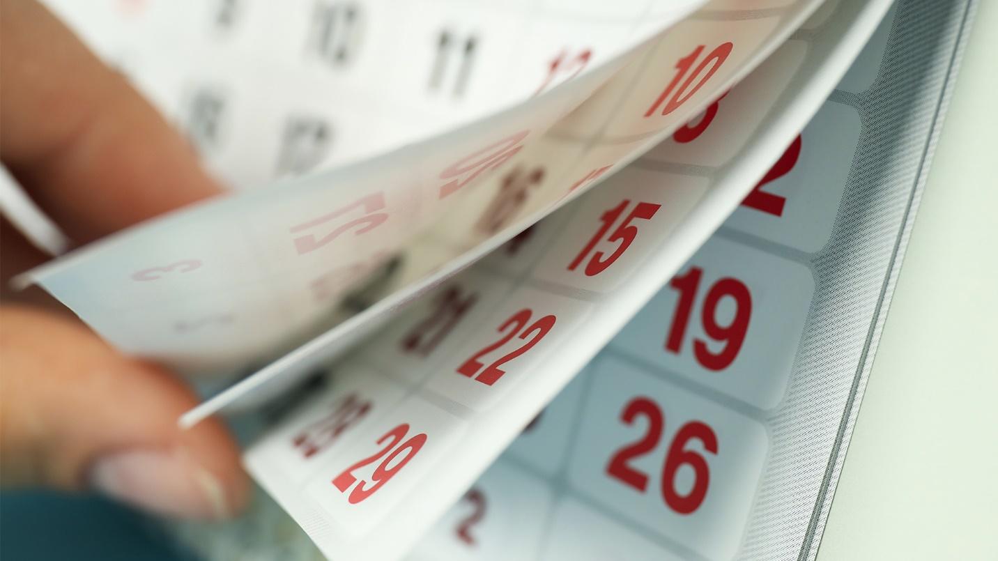 A hand flips through the pages of a calendar in a section explaining the requirements of the presence test that must be passed to achieve bona fide residency in Puerto Rico.
