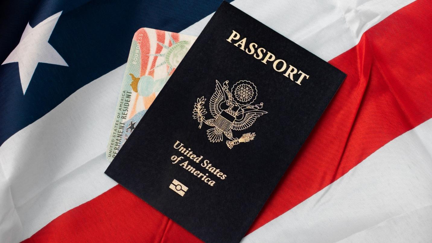 A passport and green card rest on a U.S. flag in a section that describes how American citizens can renew their passports in Puerto Rico.
