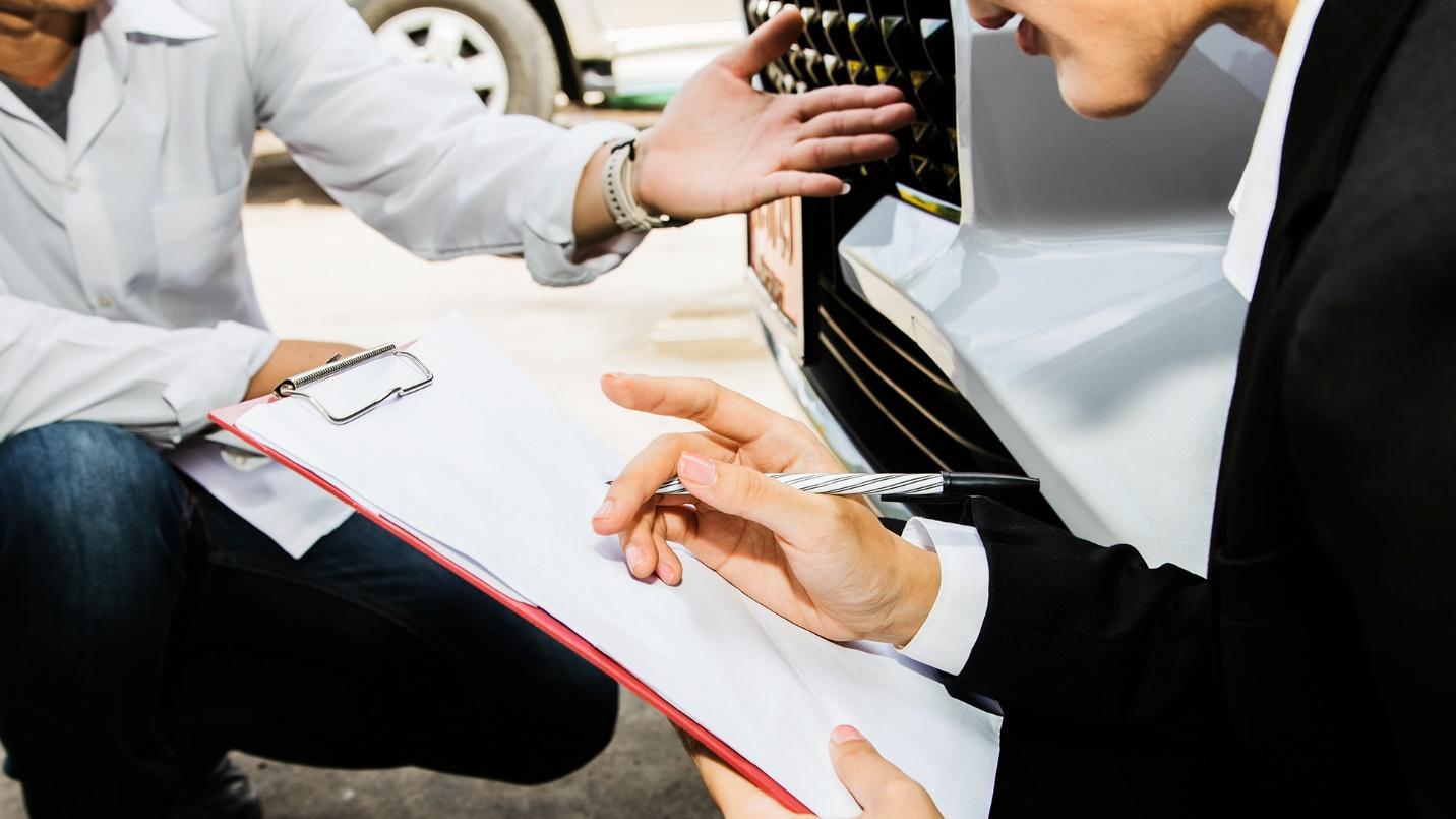 agent teaching a man how to fill out a form for vehicle registration in Puerto Rico