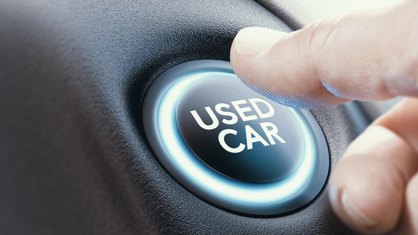 man deciding on whether to push used car button before buying it