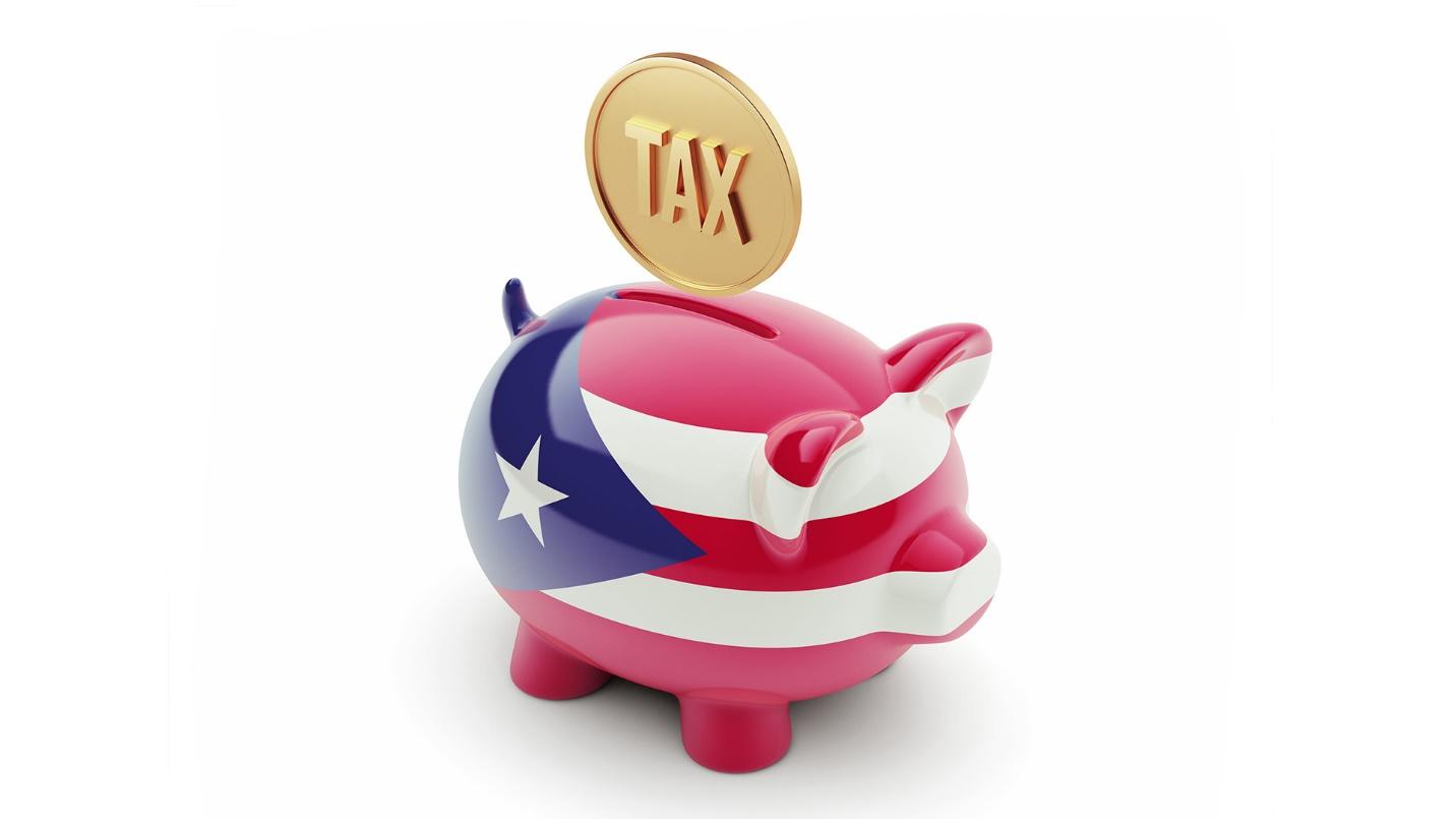 A golden coin imprinted with the word “tax” hovers above a piggy bank painted to look like the Puerto Rican flag in a section about why Puerto Rico is a tax haven for cryptocurrency investors.