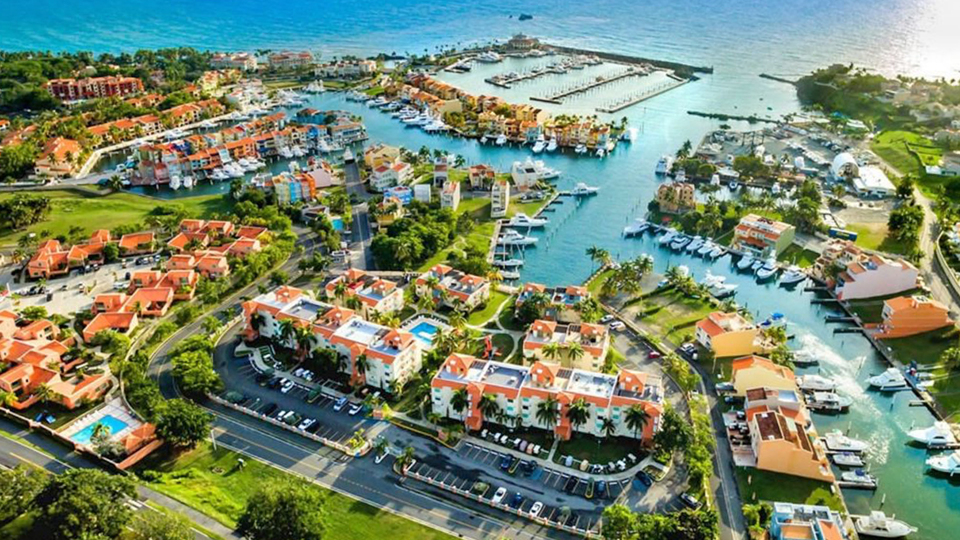 Bird’s eye view of Palmas del Mar’s marina with boats, resort buildings, and greenery.
