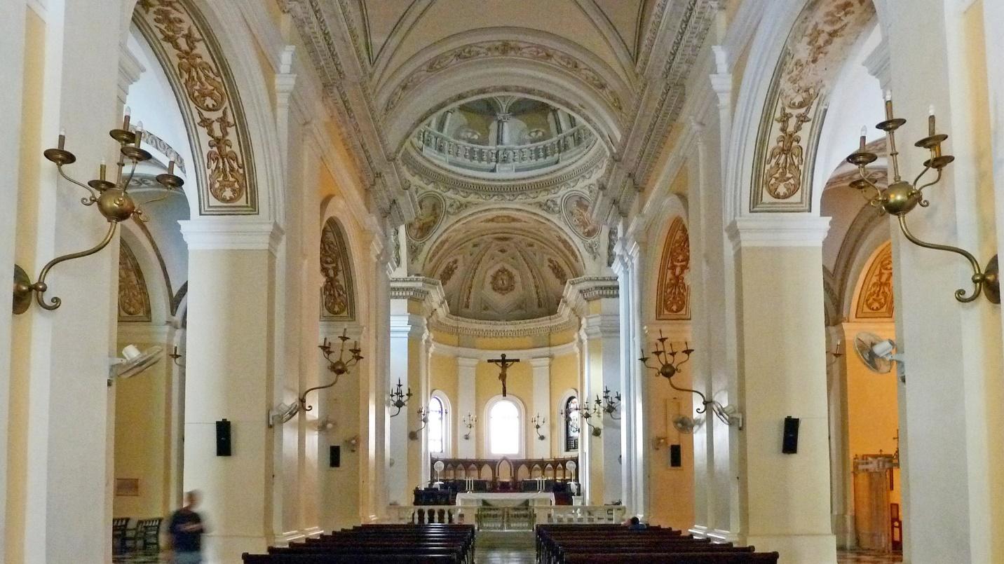 The beige and white nave of San Juan Cathedral in a section about the building’s history and how to visit it.