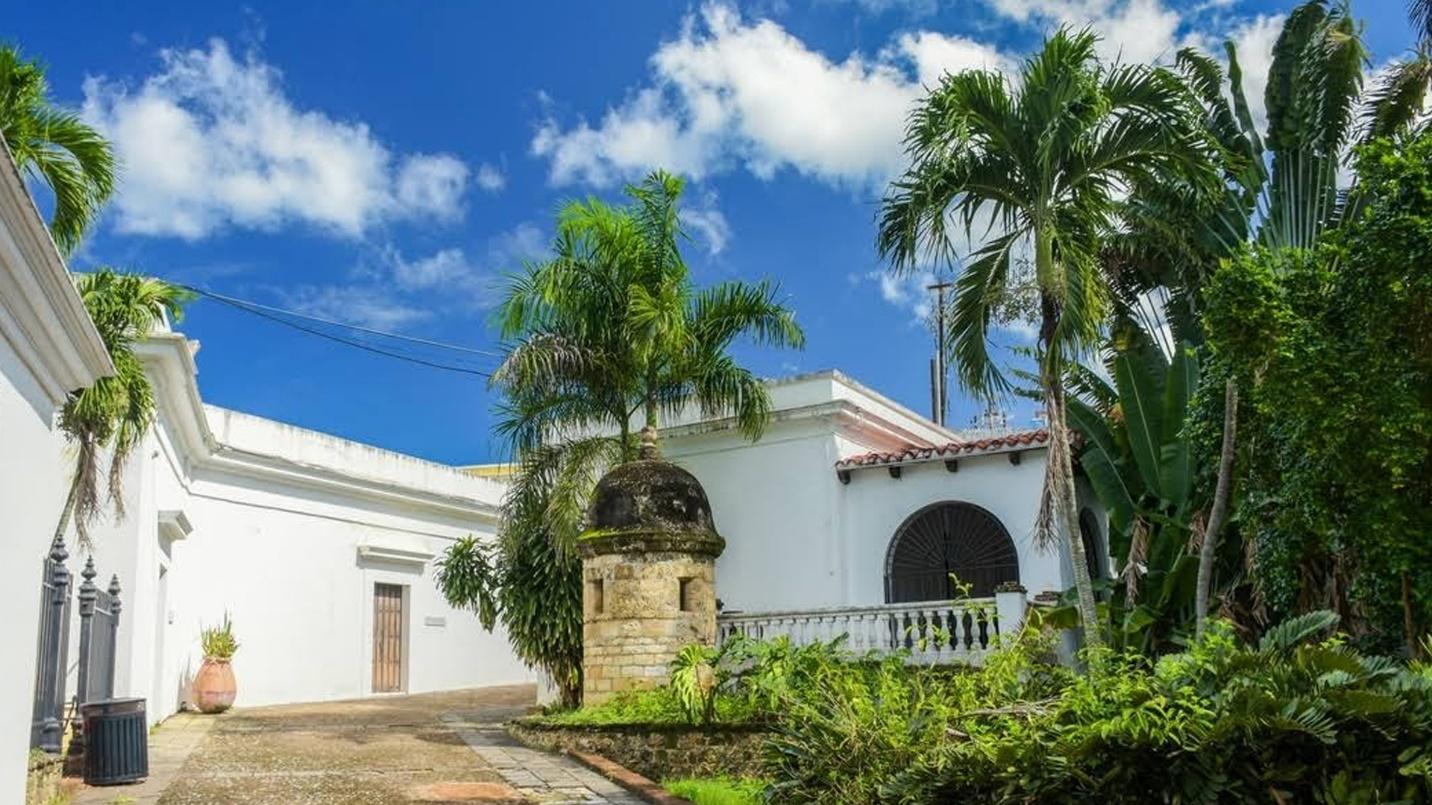 The white walls of Casa Blanca Museum and green palm trees in a section about the building’s past and what visitors can see.