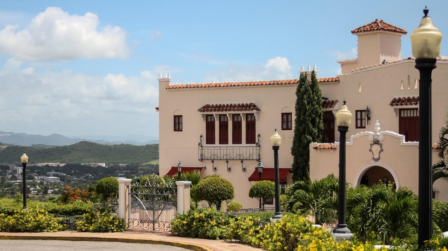The peach walls of Serralles Castle surrounded by foliage in a section about the mansion’s museum of rum and sugar cane.