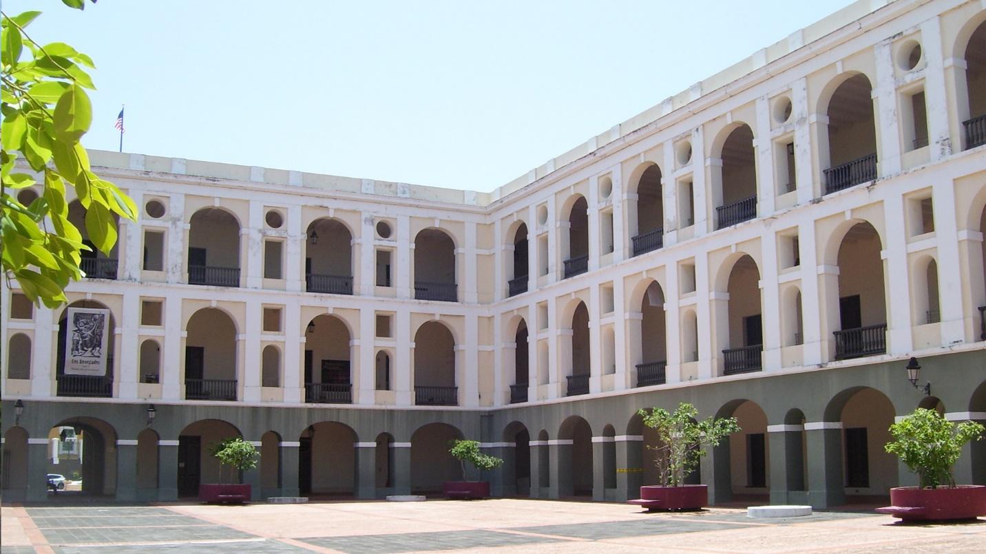 Cuartel de Ballajá’s courtyard with three stories of pink, white, and gray arches in a section about the site and its museum.