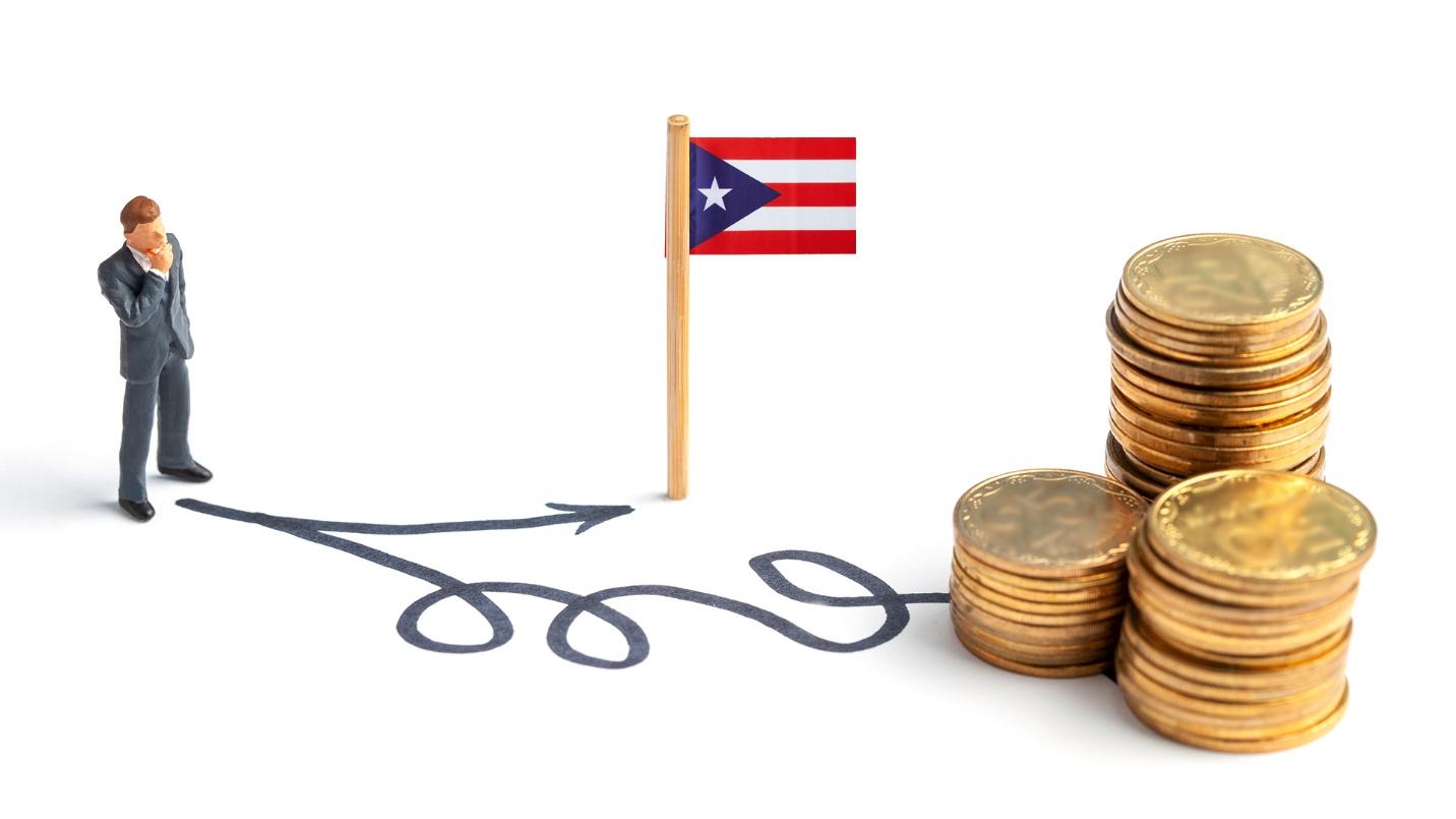 A man in a suit ponders pathways that lead to a Puerto Rican flag and stacks of golden coins in a section about how to save money by relocating to Puerto Rico. 