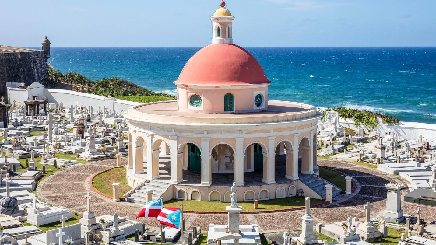 A red-domed and columned chapel is surrounded by gravestones at Santa Maria Magdalena de Pazzis, a famous cemetery by the sea in Old San Juan.
