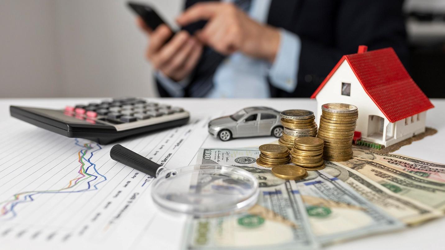 A man in a suit holds a smartphone beside a table filled with a calculator, magnifying glass, currency, charts, a toy car, and a model house in a section about how PRelocate can save you money. 