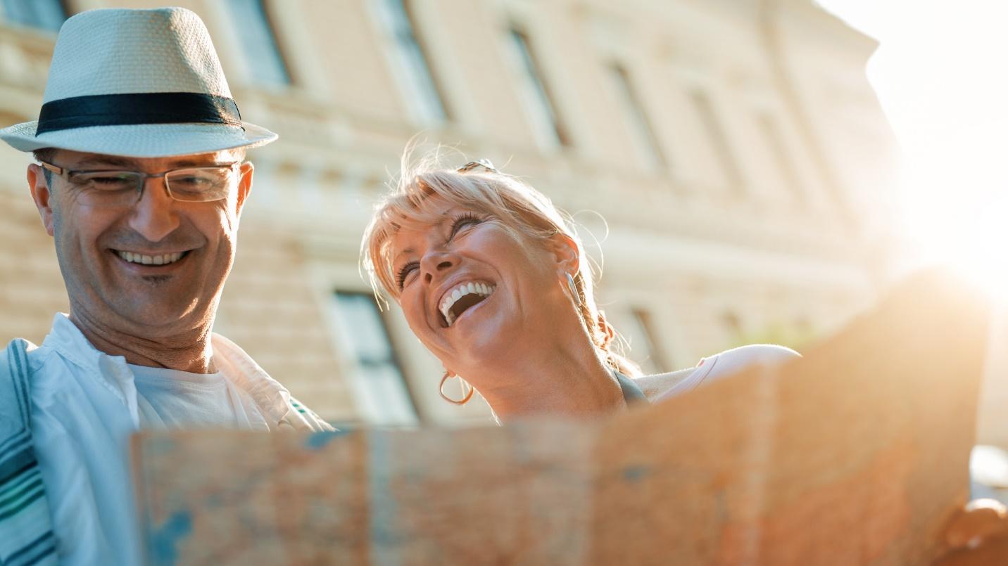 A happy couple laugh while viewing a map in a section about what to see and do in San Juan, Puerto Rico.