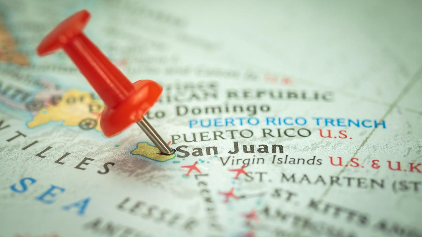 A red push pin marks San Juan on a map of the Caribbean in a section about tourism in and around the island’s capital.
