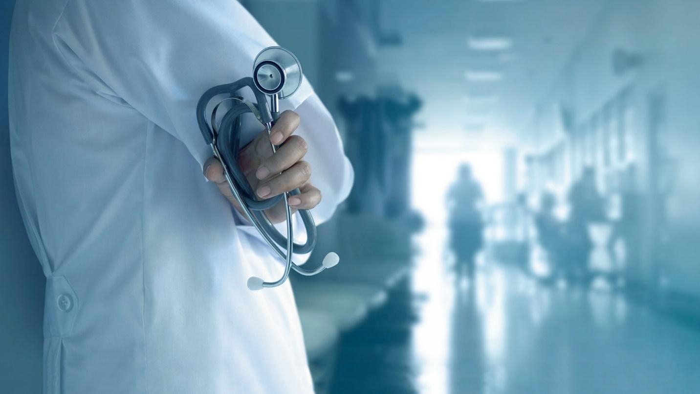 View of a hospital corridor and doctor holding a stethoscope.