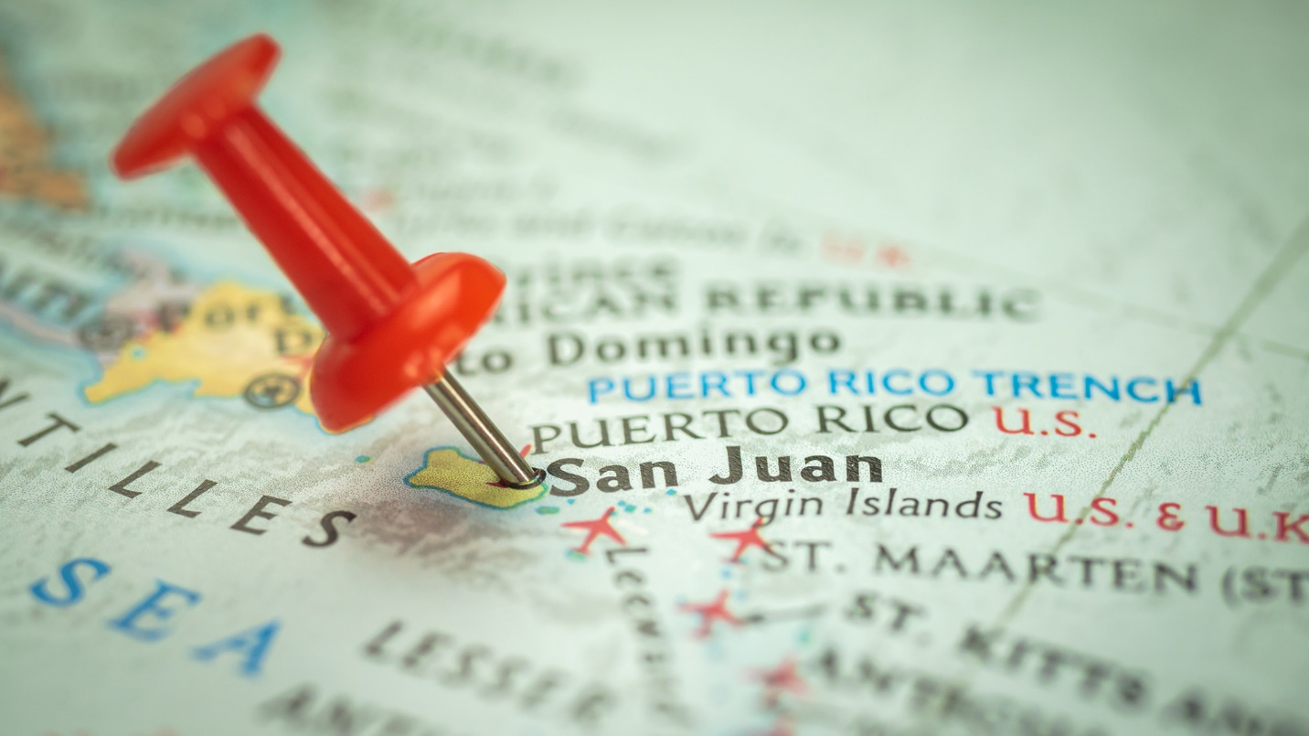 A red push pin marks San Juan on a map of the Caribbean.