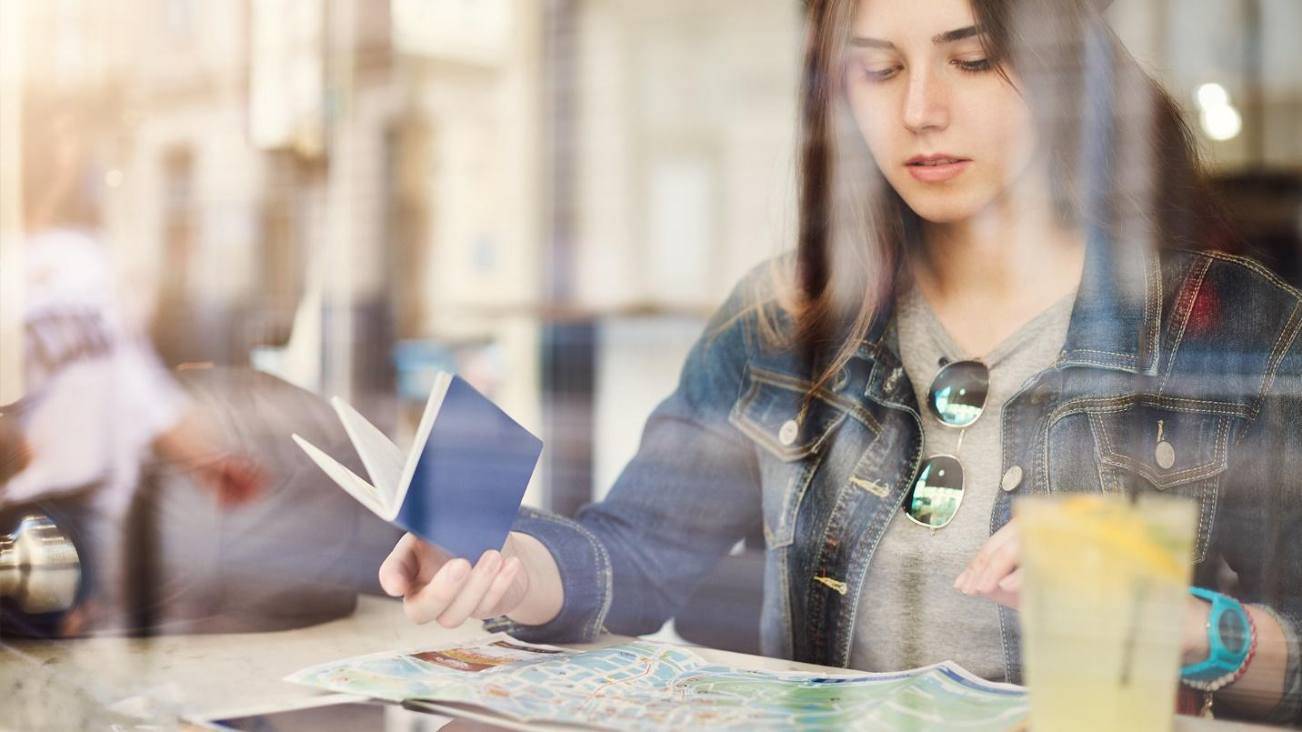Woman in a blue jacket reviewing a map of Guaynabo while holding a notebook