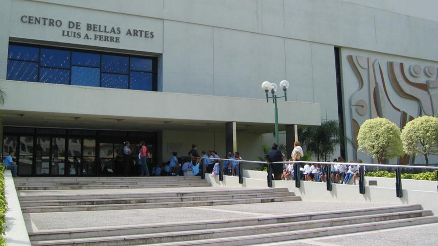 The entrance to Centro de Bellas Artes (Guaynabo Performing Arts Center) with people sitting and standing outside.
