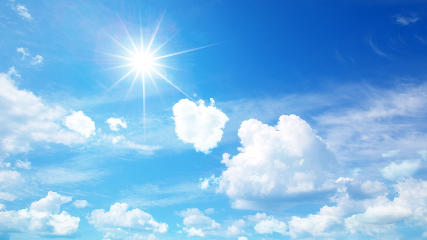 The sun shines brightly in a blue sky with white clouds.