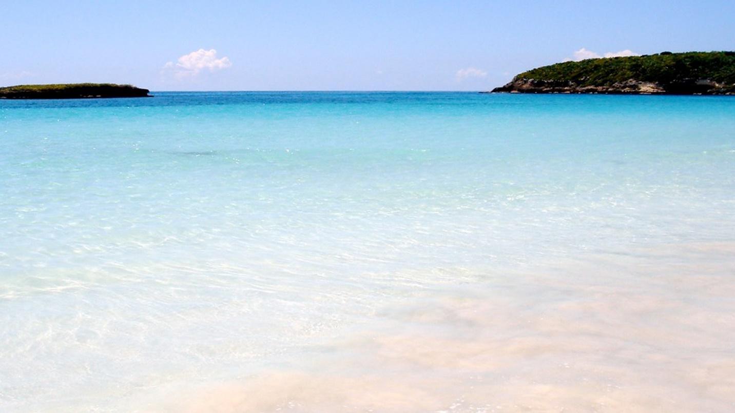 The sea and sand with two islands in the distance in a section about Vieques Island. 