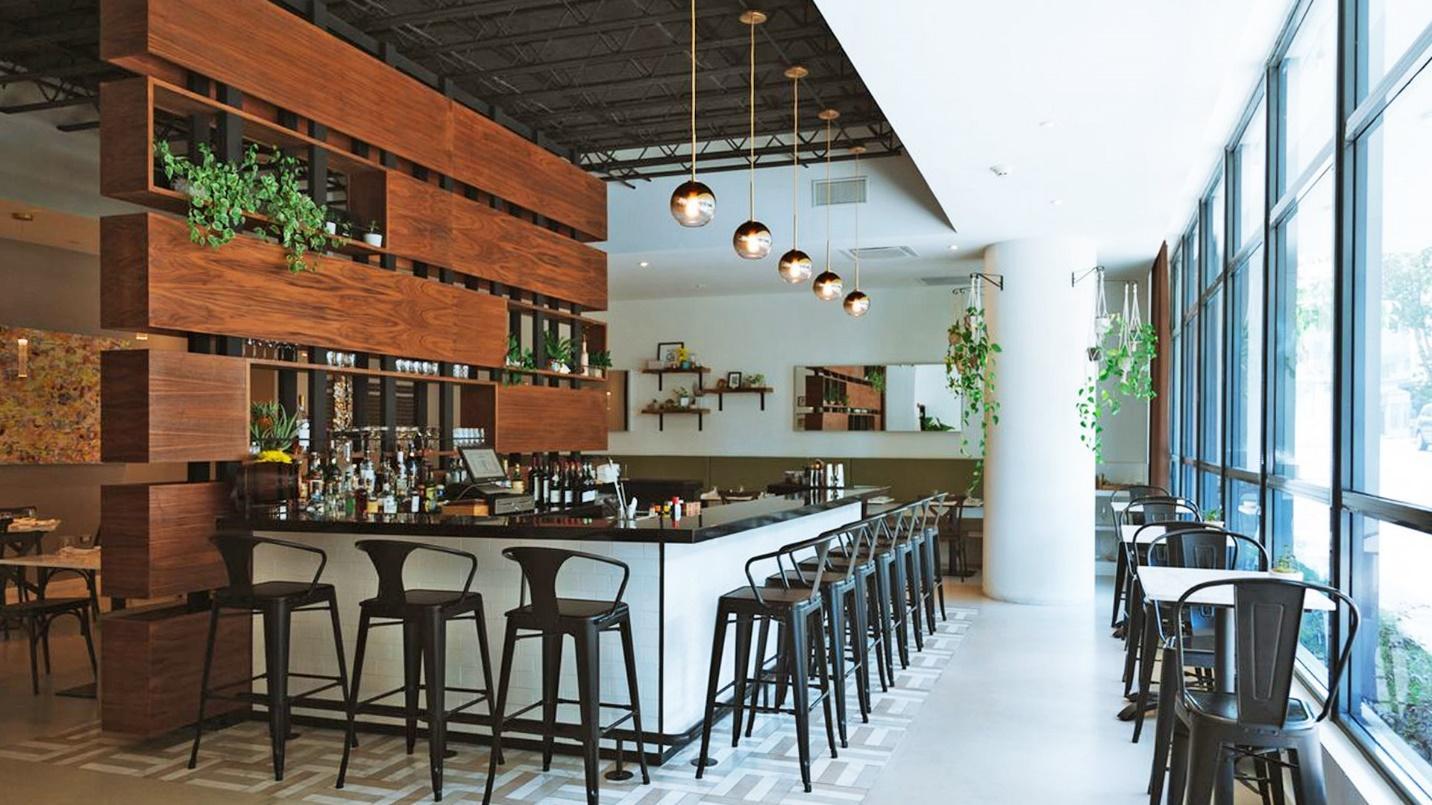 The bar and tables at gourmet restaurant Vianda in a section about the restaurant’s accolades, select dishes, and hours of operation. 