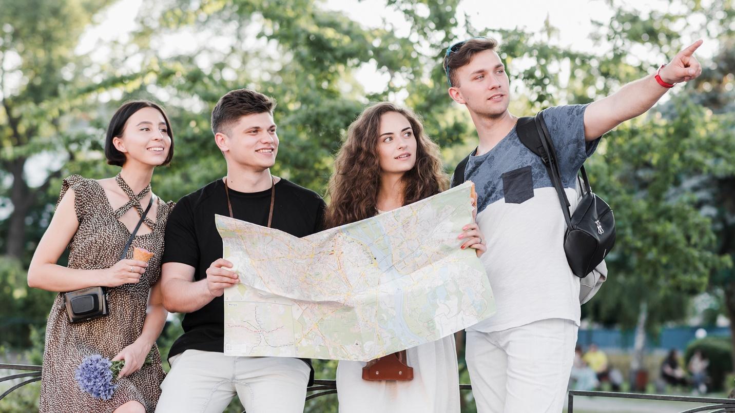 A small group of young men and women stare into the distance while consulting a map in a section describing sightseeing in Puerto Rico and favorable press coverage of it.
