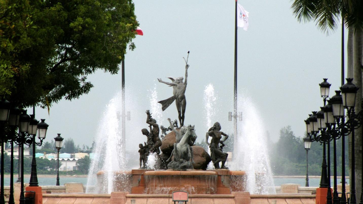 Jets of water surround a collection of bronze statues by San Juan harbor in a section about Raices Fountain. 