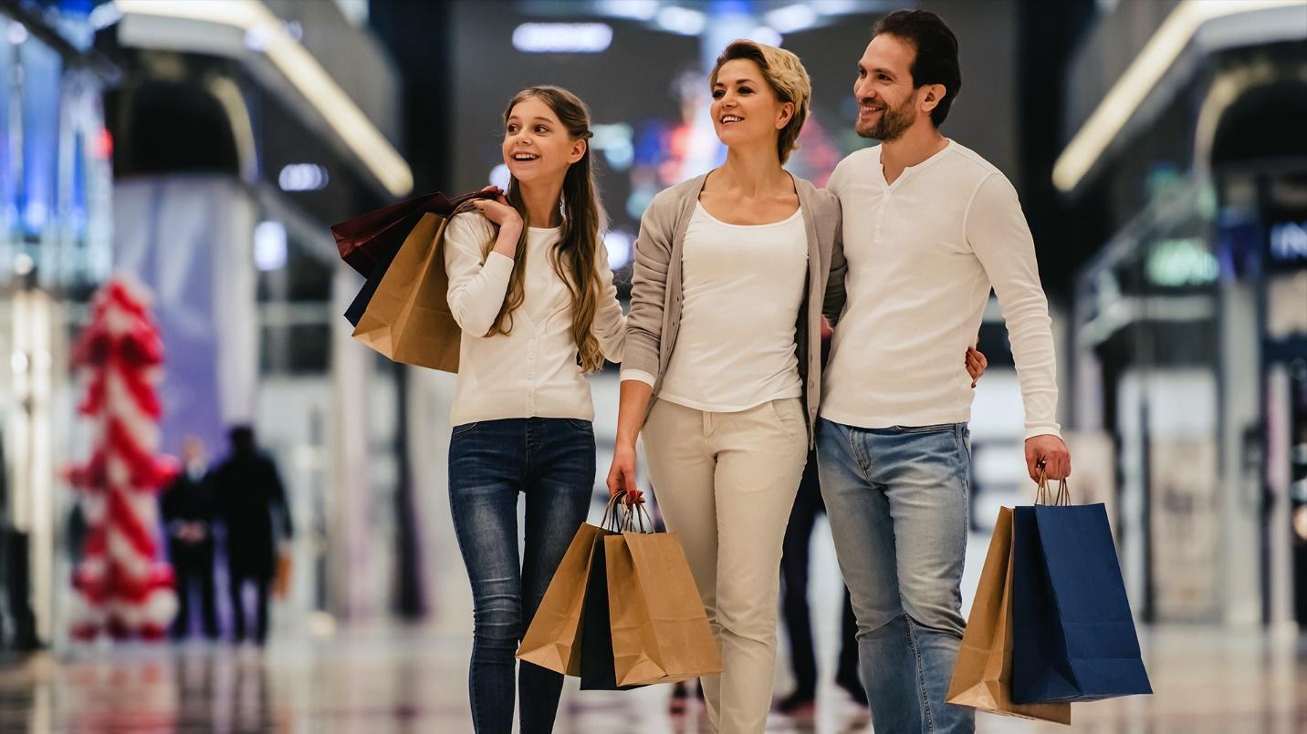 A couple and their daughter carry shopping bags while they stroll the corridors between shopping outlets in a section about Plaza Las Americas, the largest mall in Puerto Rico. 