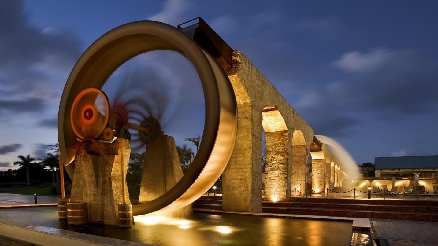 Water pours over the side of a series of arches that make up a giant watermill in a section about a modern waterpark at Dorado Beach. 