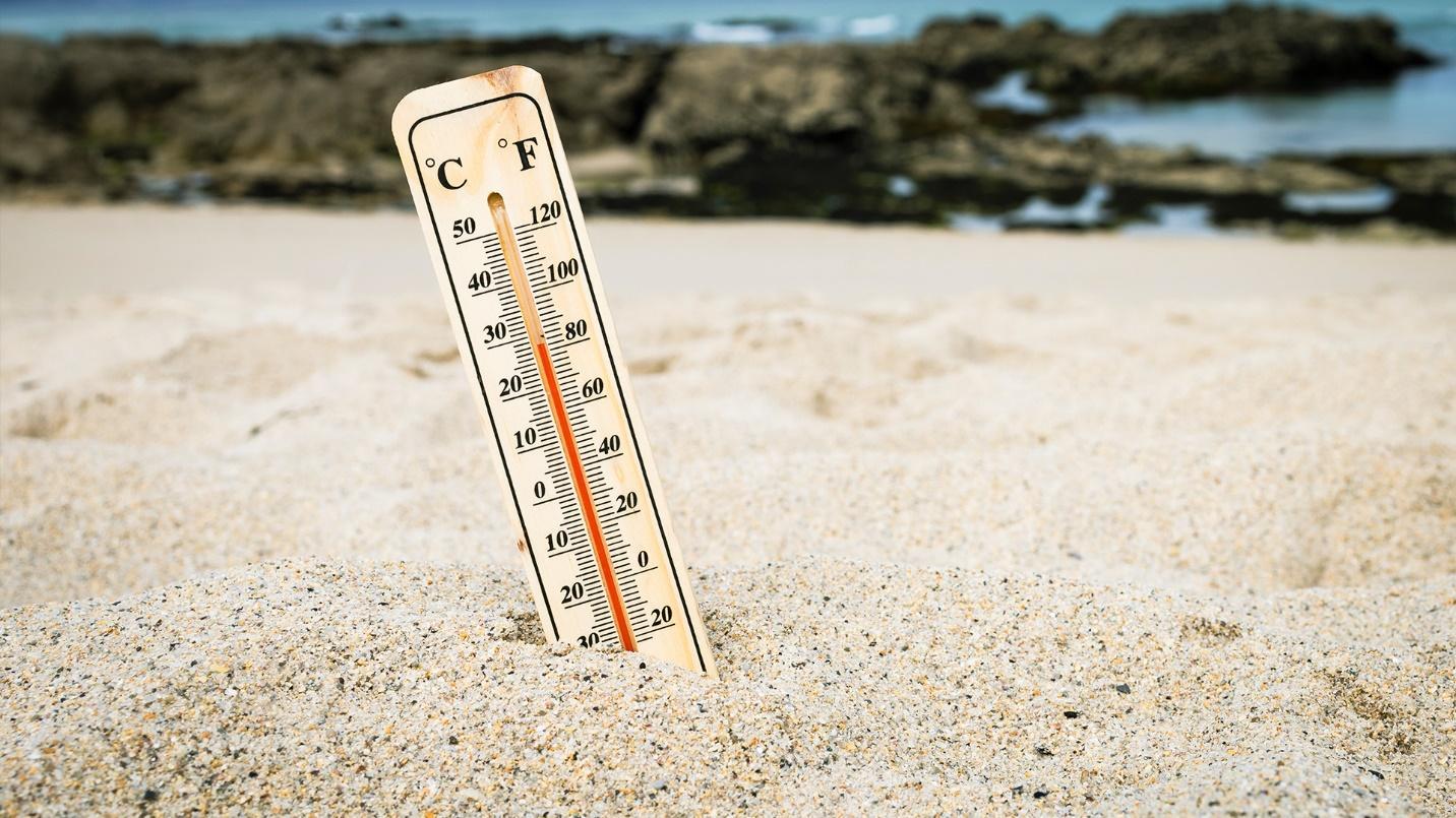 A thermometer in the sand displays the temperature in a section about the warm sun and pleasant tropical weather in Rincón.