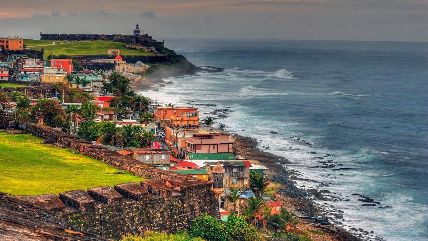 Spanish forts and properties by a rocky beach in a section that describes residential areas in Puerto Rico.