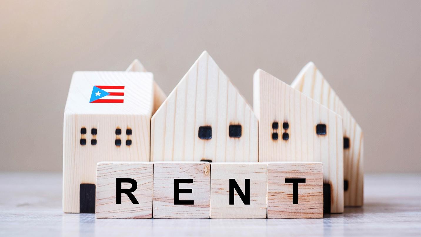 Four blocks spell out the word “RENT” in front of wooden model houses in a section previewing PRelocate’s guide to renting in Puerto Rico.