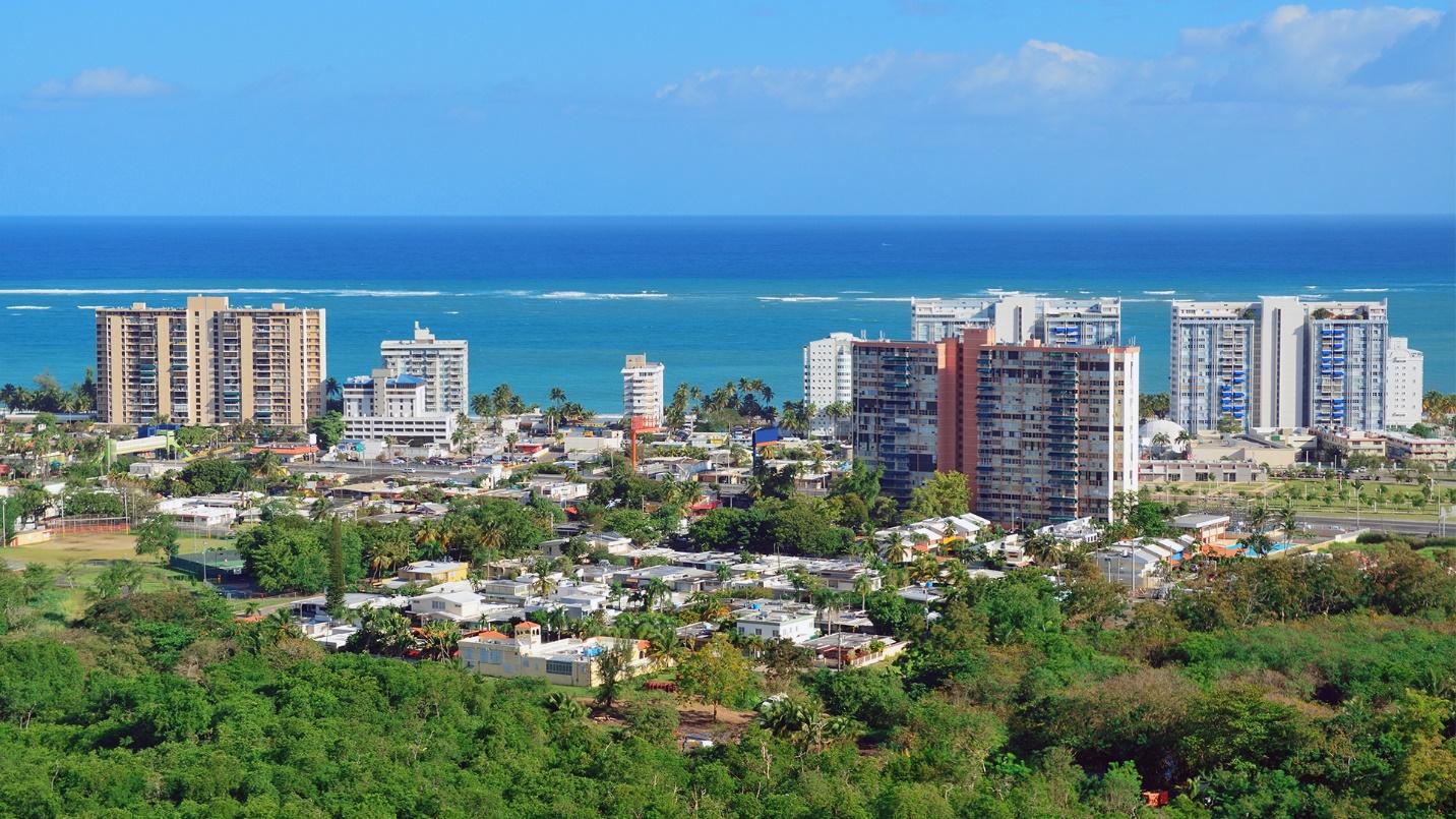 High-rise buildings, residential areas, and forest near the beach in a section that outlines rental options in Puerto Rico.