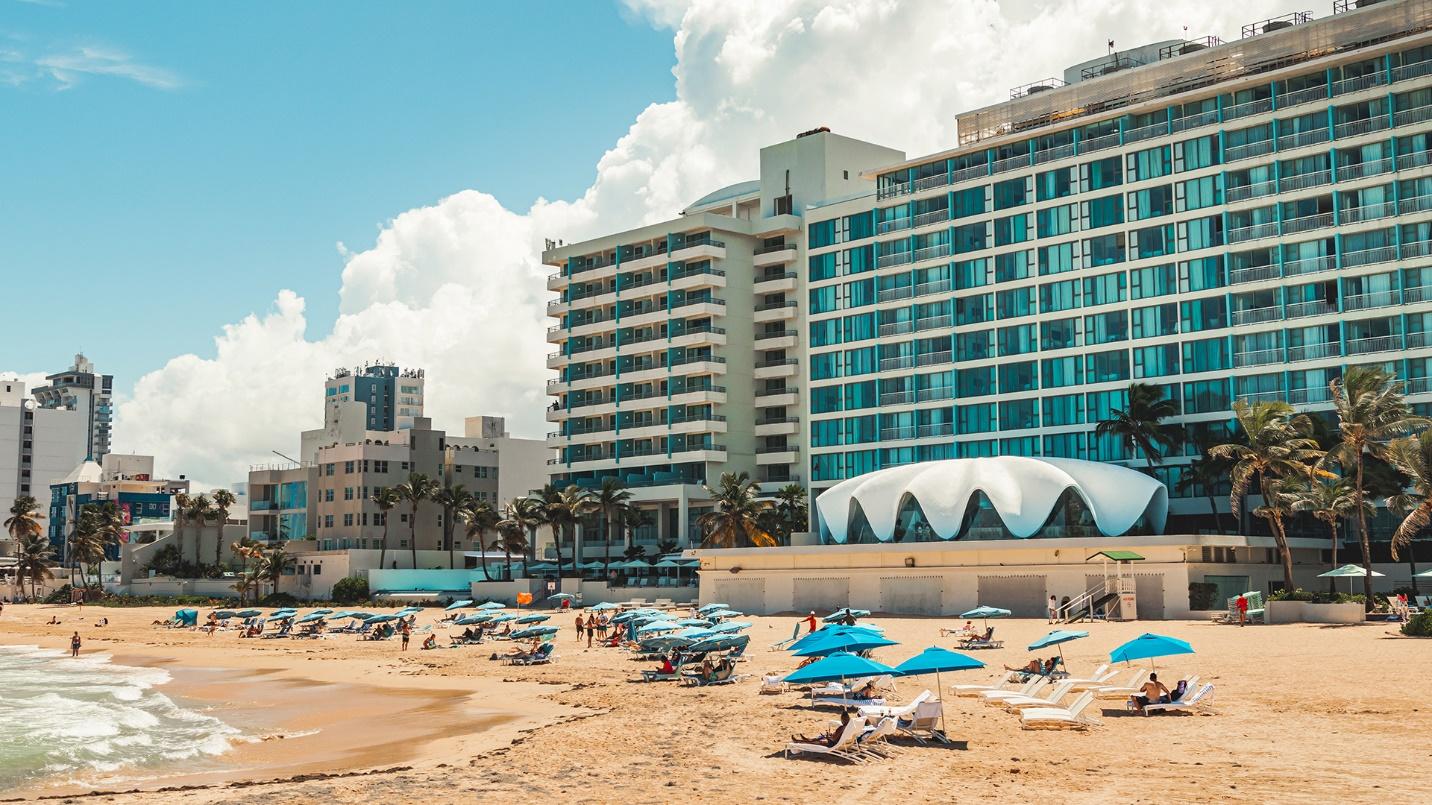 The beach, La Concha Hotel, and other oceanside properties in a section describing Condado’s location.