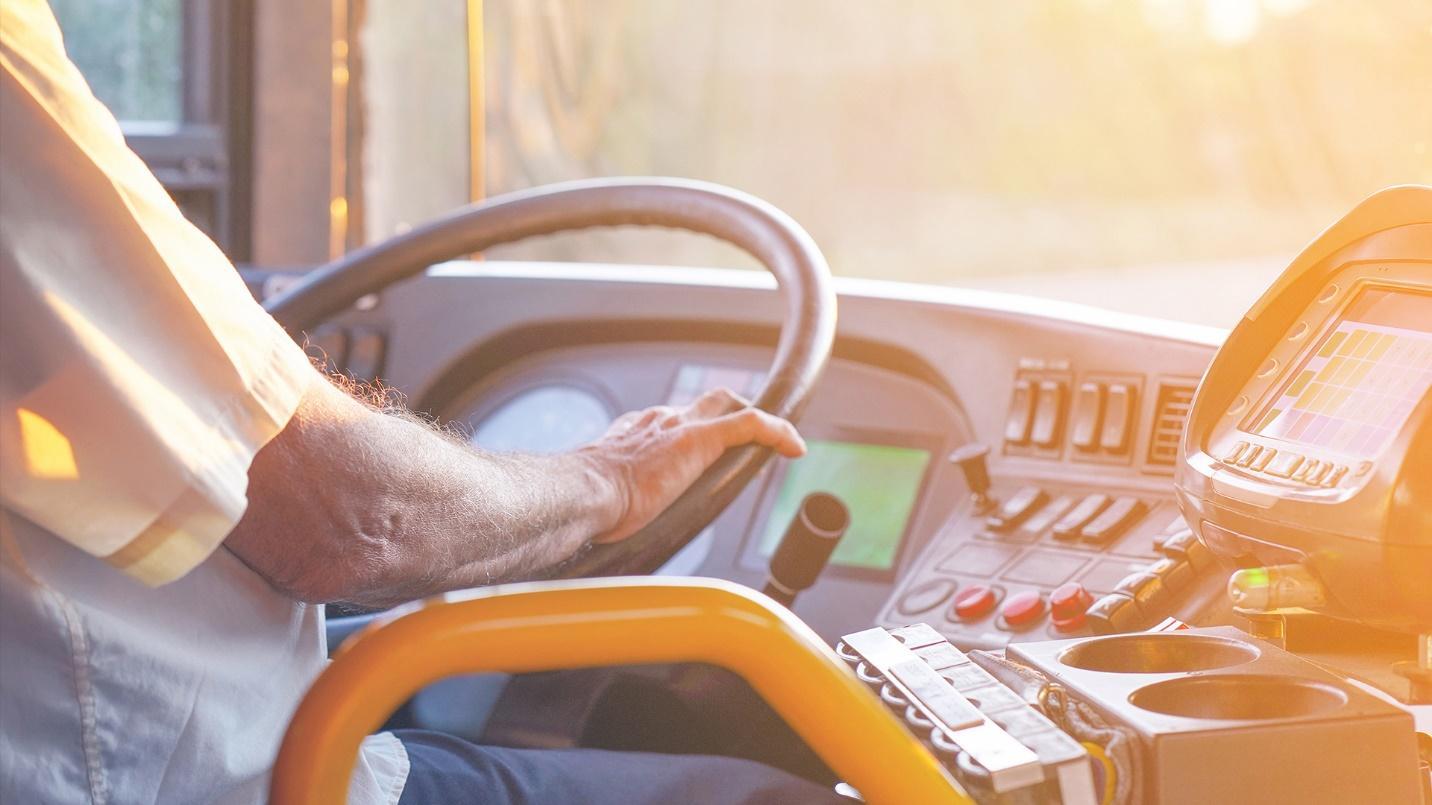 A man drives a large vehicle toward the sun in a section about transportation in and around the neighborhood. 