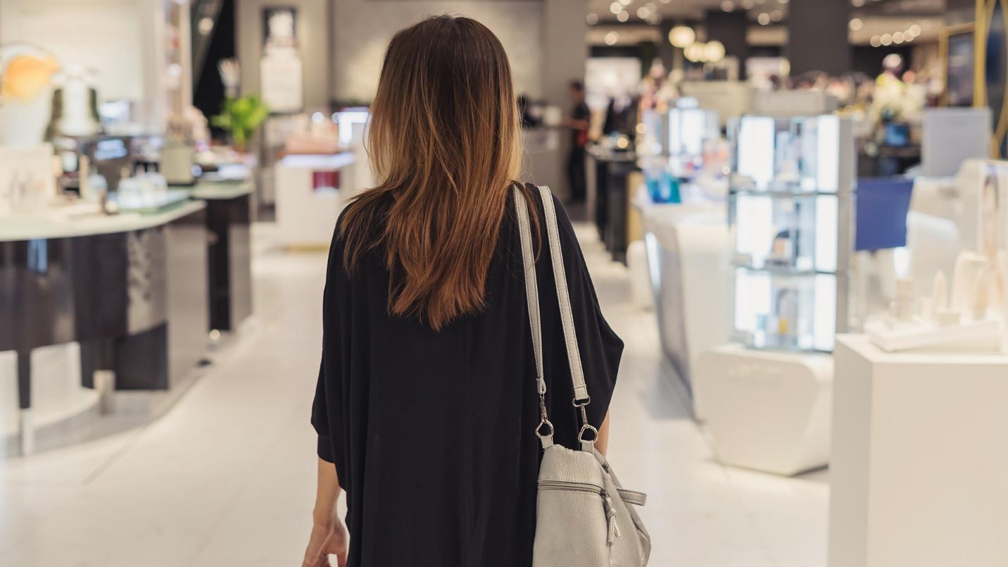 A woman dressed in black walks down a store aisle in a section about shopping in Condado. 