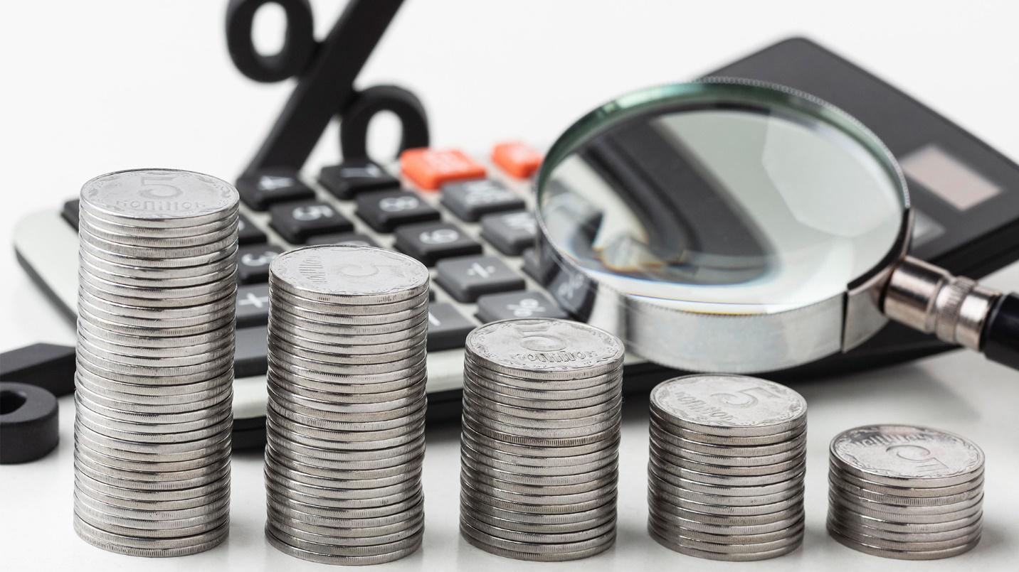 A calculator and coins, cost-cutting