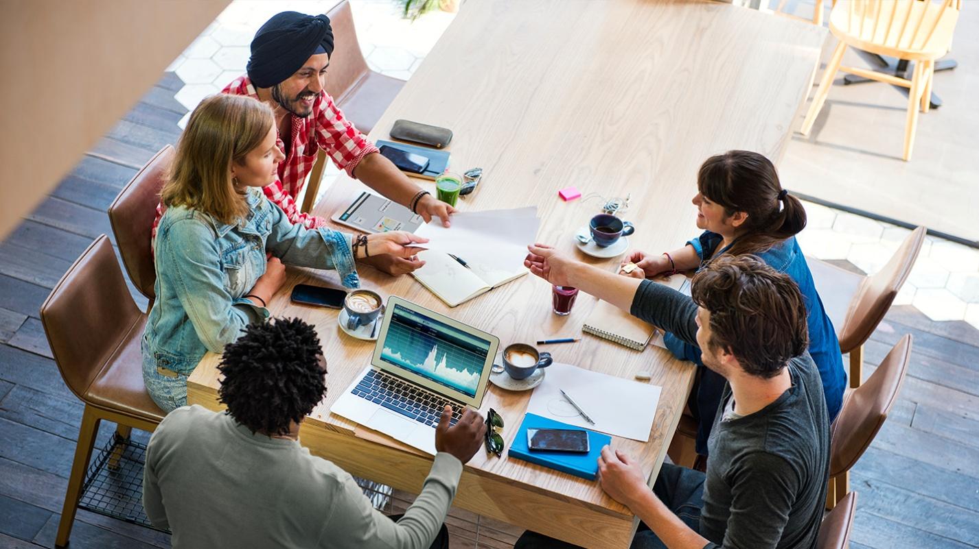 Remote workers who moved to Puerto Rico with PRelocate collaborating around a table, reflecting how professionals network and make friends.