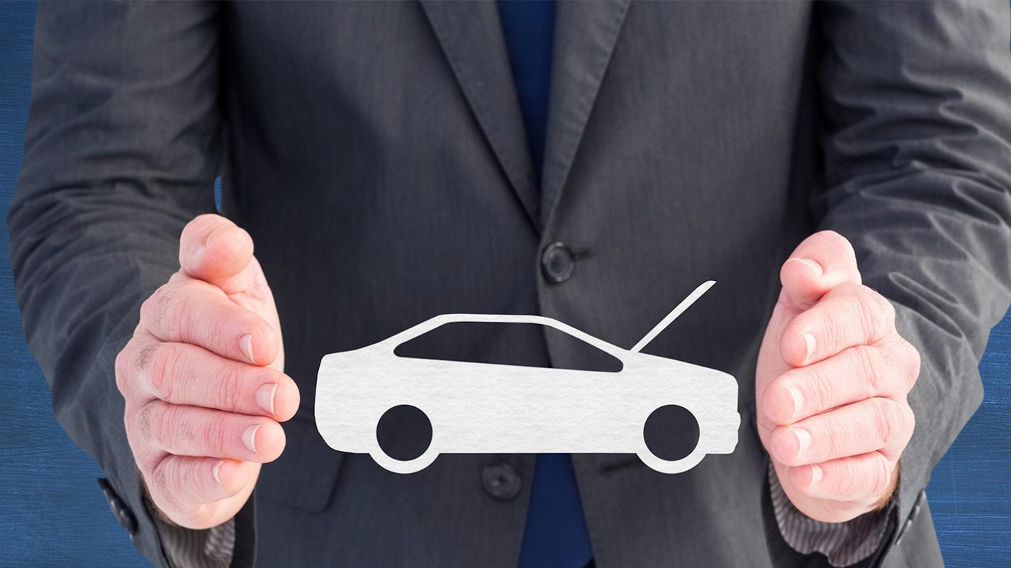 Businessman holding a car icon between his hands, symbolizing car ownership, protection, and insurance in Puerto Rico. PRelocate can help you move to Puerto Rico.