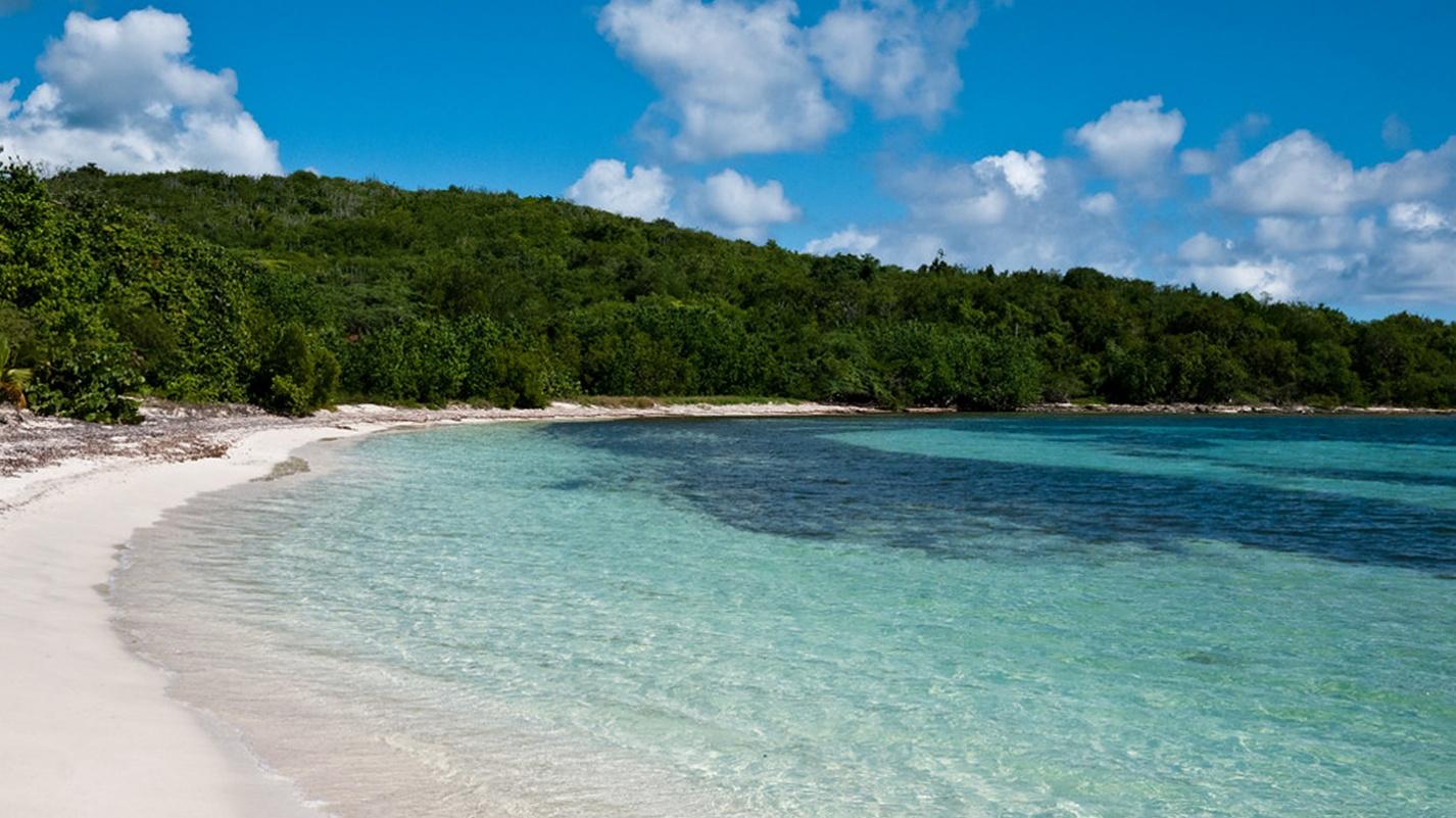 Crystal-clear waters and untouched shoreline at a remote Puerto Rico beach, ideal for relaxing getaways like Playa La Chiva.